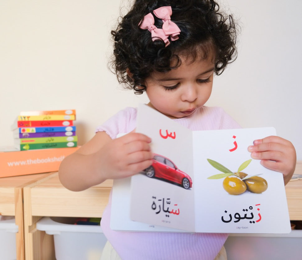 Toddler flipping through Arabic book