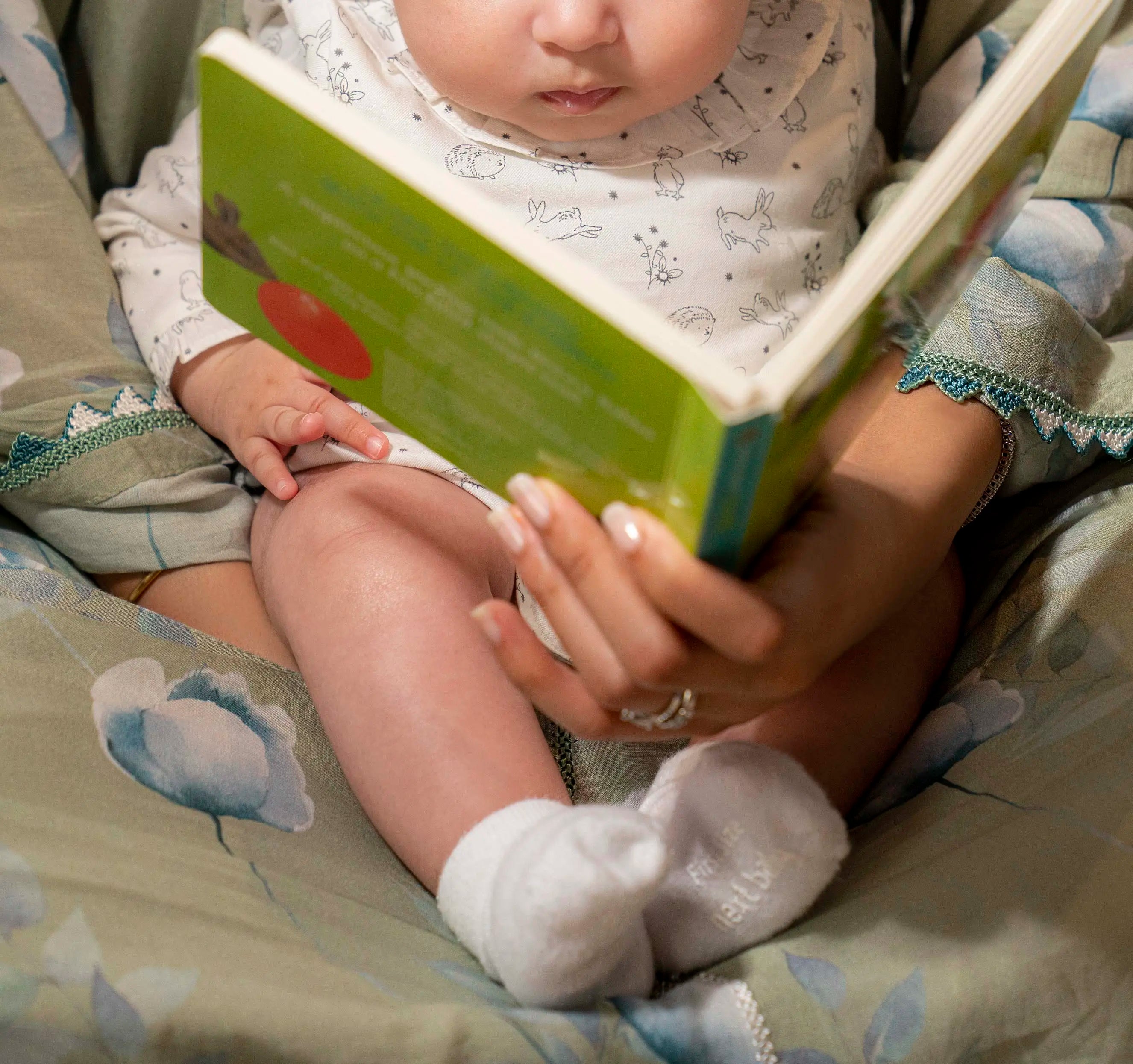 mother reading to her infant a book